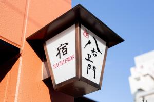 une horloge noire et blanche sur le côté d'un bâtiment dans l'établissement Yado Hachiemon, à Osaka