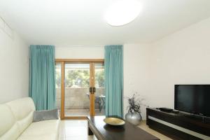 a living room with a couch and a tv at 107 - King David Residence - Jerusalem-Rent in Jerusalem