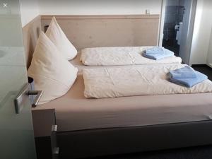 een bed met twee kussens erop bij Pension Gasthaus Zur Forelle in Seeburg