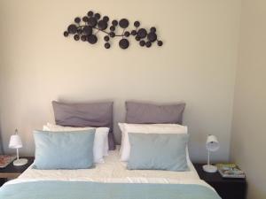 um quarto com uma cama e um relógio na parede em Robertson Stays em Robertson