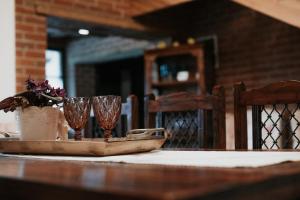 a table with two wine glasses and a vase on it at La Saca 42 in Saca