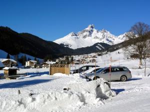 ein schneebedeckter Parkplatz mit einem schneebedeckten Berg in der Unterkunft Buschhäusl in Filzmoos