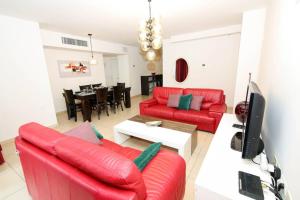 a living room with two red couches and a table at 108 - King David Residence - Jerusalem-Rent in Jerusalem