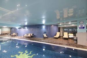 a hotel lobby with a swimming pool and chairs at 108 - King David Residence - Jerusalem-Rent in Jerusalem