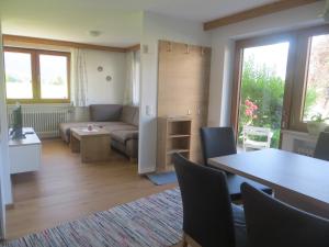 una sala de estar con un sofá y una mesa en Beim Broi inkl Chiemgau-Karte, en Ruhpolding