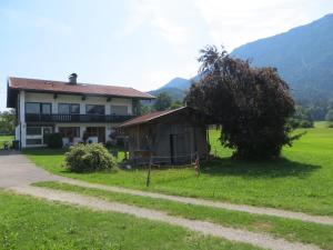una casa con un árbol al lado de un camino de tierra en Beim Broi inkl Chiemgau-Karte, en Ruhpolding