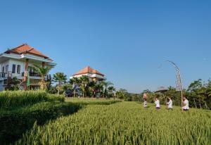 um grupo de crianças a caminhar por um campo de relva em Cenik Villa Ubud em Ubud