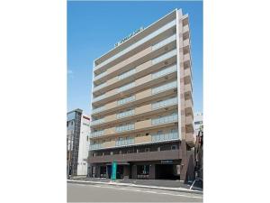 a tall building on a street in front of a building at Amagasaki Plaza Hotel Hanshin Amagasaki in Amagasaki