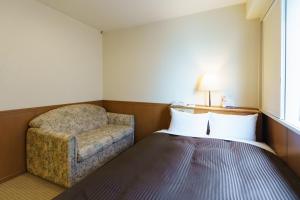 a hotel room with a bed and a chair at Kyoto Horikawa Inn in Kyoto