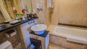 a bathroom with a sink and a bath tub at The Lokha Legian Resort & Spa in Legian