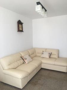 - un canapé blanc avec deux oreillers dans l'établissement Simona‘s apartment Mackerel, à Mamaia Nord – Năvodari