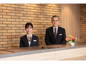 two people in suits sitting at a desk at Amagasaki Plaza Hotel Hanshin Amagasaki in Amagasaki