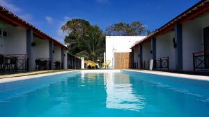 a swimming pool with blue water in front of two buildings at Positano Alona Beach Panglao in Panglao