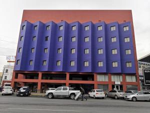 モンテレイにあるHotel Son- Mar Monterrey Centroの前に車が駐車されている青い建物