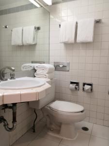 a bathroom with a toilet and a sink and towels at Hotel Son- Mar Monterrey Centro in Monterrey