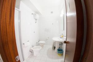 a bathroom with a toilet, sink, and mirror at Hotel Eden in San Domino