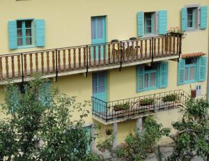 un bâtiment avec des fenêtres bleues et des balcons avec des plantes dans l'établissement Authentic traditional Soca Valley home, à Kanal