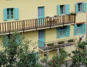 a building with blue windows and balconies with plants at Authentic traditional Soca Valley home in Kanal
