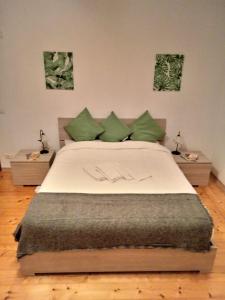 a bedroom with a large bed with green pillows at Villa sulle nuvole in San Raffaele Cimena