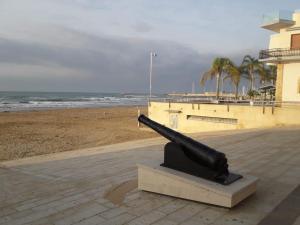 a statue of a gun next to the beach at Casa Incanto Marina Bis in Marina di Ragusa