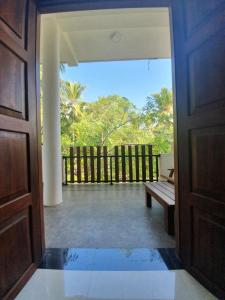 an open door to a porch with a bench at Ambel Homestay in Anuradhapura