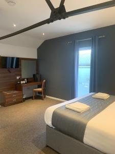 切斯特的住宿－Oakwood Farm Mews Chester，一间卧室配有一张床、一张书桌和一个窗户。