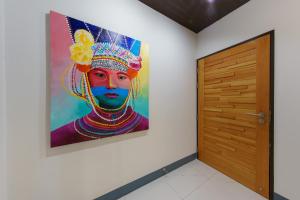a painting of a woman on a wall next to a door at Jiang Mai 81 in Chiang Mai