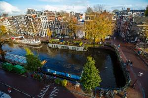 a bridge over a river in a city with buildings at Amsterdam Wiechmann Hotel in Amsterdam