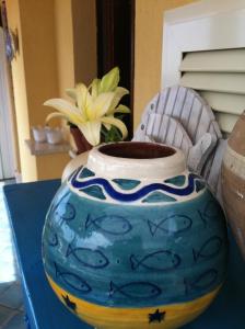 un jarrón azul sentado en una mesa con una planta en B&B Il Vicolo Di Pizzo, en Pizzo