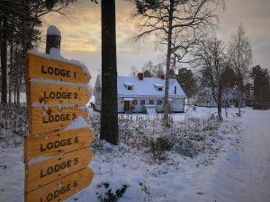 YtterhogdalVildmarks Lodge的房屋前雪中的木头标志