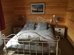 a bedroom with a metal bed in a wooden wall at RedWood Lodge in Ludlow
