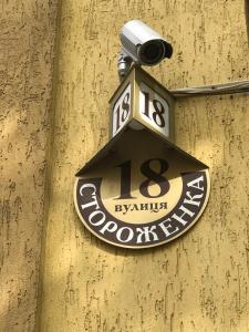 a sign on the side of a building with a light at Hotel 18 in Lviv