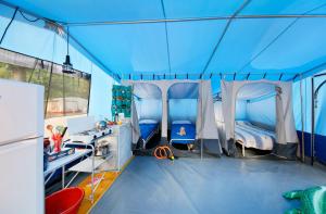 a room with two beds in a blue tent at Albatross Mobile Homes on Camping Bijela Uvala in Poreč