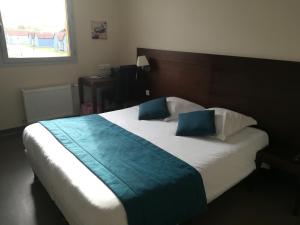 a bedroom with a large bed with a blue blanket at Le Port de Decize in Decize