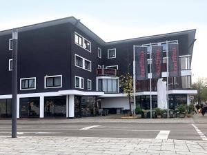 un edificio negro en una calle con un estacionamiento en DORMERO Hotel Burghausen, en Burghausen