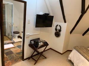 a room with a tv on a wall with a chair at Ikhaya Safari Lodge in Cape Town