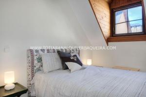 a bedroom with a bed with two lamps and a window at Torán by Totiaran in Baqueira-Beret