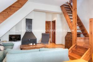 a living room with a blue couch and stairs at Torán by Totiaran in Baqueira-Beret