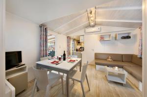 mały salon ze stołem i kanapą w obiekcie Albatross Mobile Homes on Camping Bella Italia w mieście Peschiera del Garda