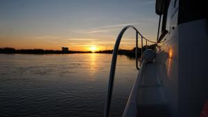a boat in the water with the sunset in the background at La Rochelle sur L'eau in La Rochelle