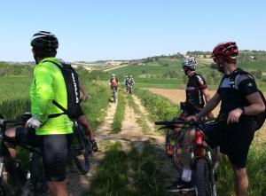 a group of people riding bikes on a dirt road at Terre del Piano in Corinaldo