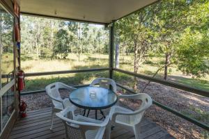 a screened in porch with a table and chairs at Scenic Rim Motel in Aratula