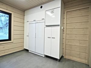 una cocina con armarios blancos y una ventana en Levillas Kuppimaantie Villas, en Levi