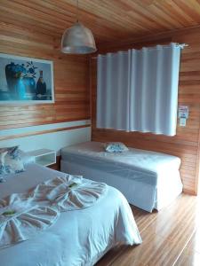 a bedroom with two beds and a window at Pousada 3 Irmaos in Urubici