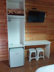 Habitación con escritorio, 2 taburetes y 1 cama en Pousada 3 Irmaos, en Urubici