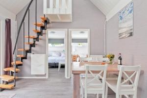 a kitchen and dining room with a staircase and a table and chairs at Vakantiewoning Westkapelle Zuidstraat 22 in Westkapelle