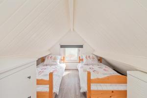two beds in a attic room with white walls at Vakantiewoning Westkapelle Zuidstraat 22 in Westkapelle