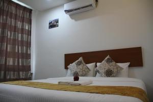 a bedroom with a large bed with white sheets and pillows at Big Apple Hotel in Kulim