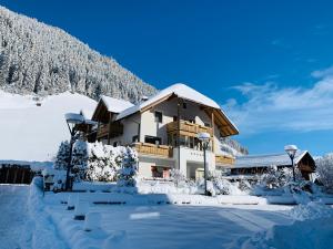 a house covered in snow in front of a mountain at Apartments Grossgasteiger in Rio Bianco
