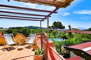 un patio con sillas y una terraza con vistas. en Green Paradise Affittacamere, en SantʼAgata sui Due Golfi